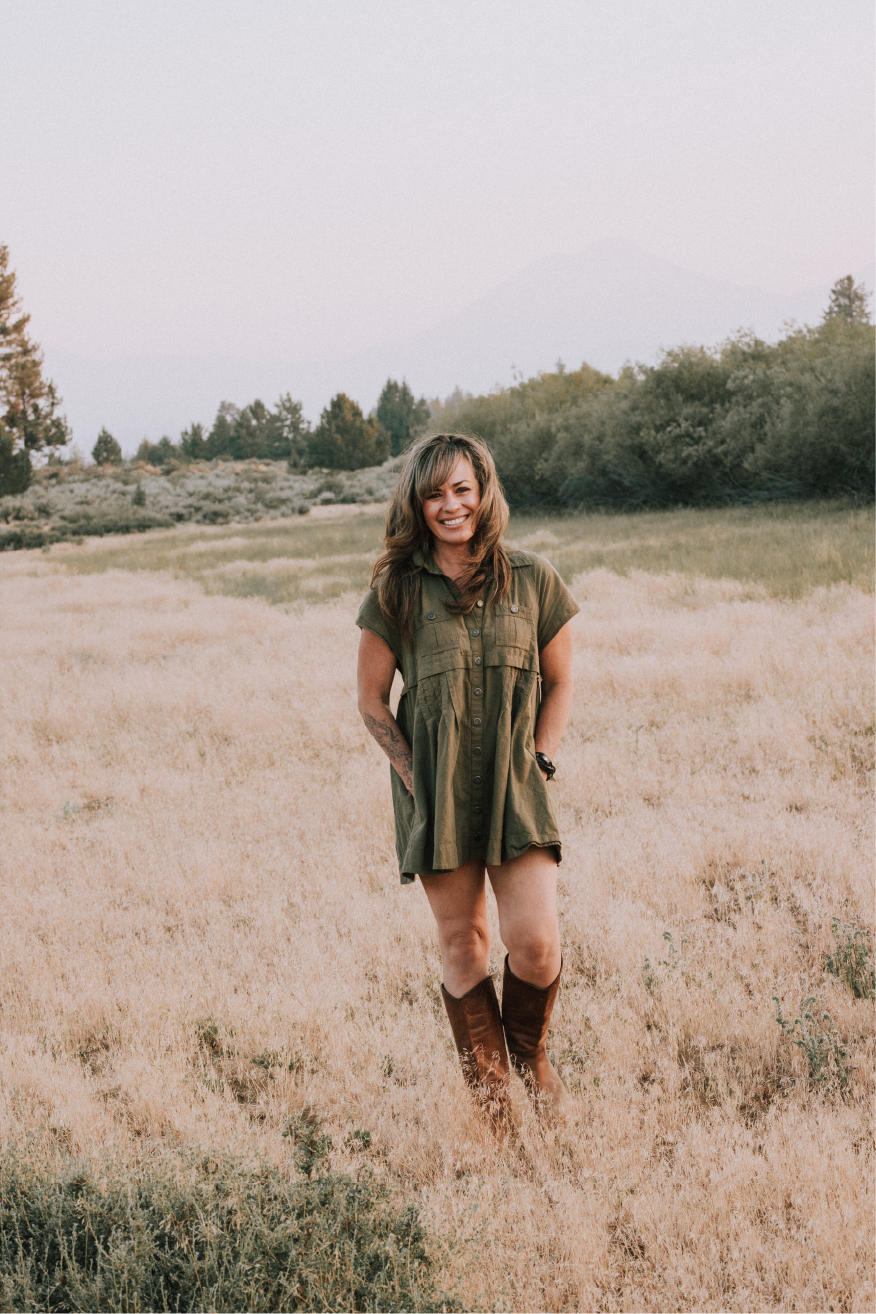 Jodi Baxter in cute green dress standing in a meadow